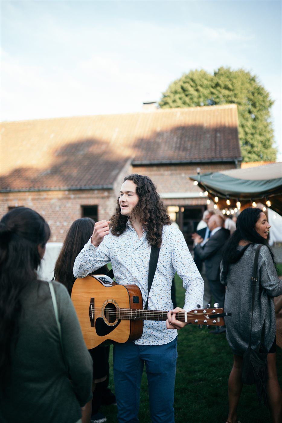 Thomas playing guitar among the wedding guests
