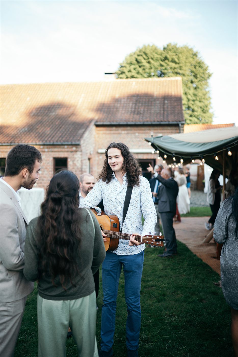 Thomas walking through the guests with his guitar